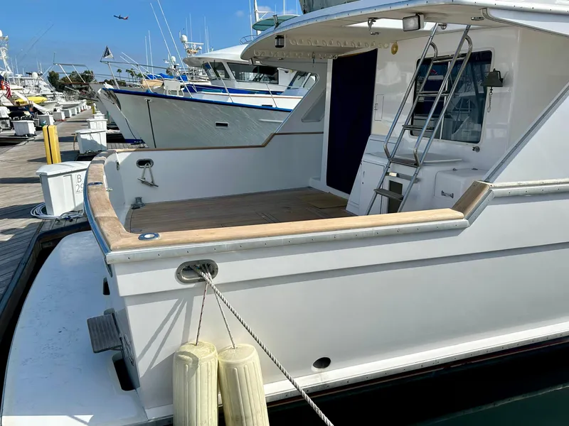 Slide: The Image of 1987 Tollycraft Pilothouse Motor Yacht docked, featuring spacious deck and sleek design. - 33