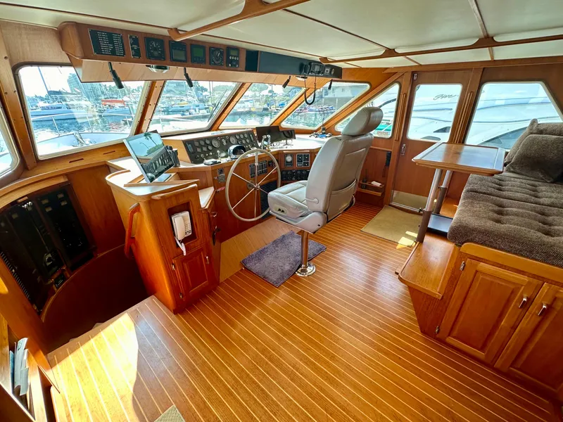 Slide: The Image of 1987 Tollycraft Pilothouse Motor Yacht interior with wooden flooring and helm station. - 5