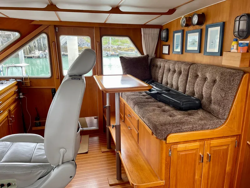Slide: The Image of 1987 Tollycraft Pilothouse Motor Yacht interior with wood paneling, seating, and helm station. - 7