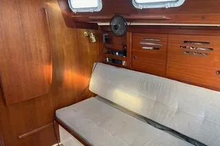 Slide: The Image of 1985 Tartan 28 Piper sailboat interior with wooden paneling and cushioned seating. - 10