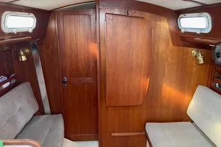 Slide: The Image of 1985 Tartan 28 Piper sailboat interior with wooden paneling and seating. - 13