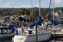 Slide: The Image of 1985 Tartan 28 Piper sailboat docked in a marina with scenic background. - 18