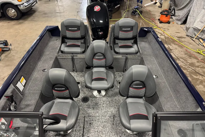 Slide: The Image of 2025 Tracker Pro Guide V-175 Combo boat interior with six gray seats in a garage setting. - 18