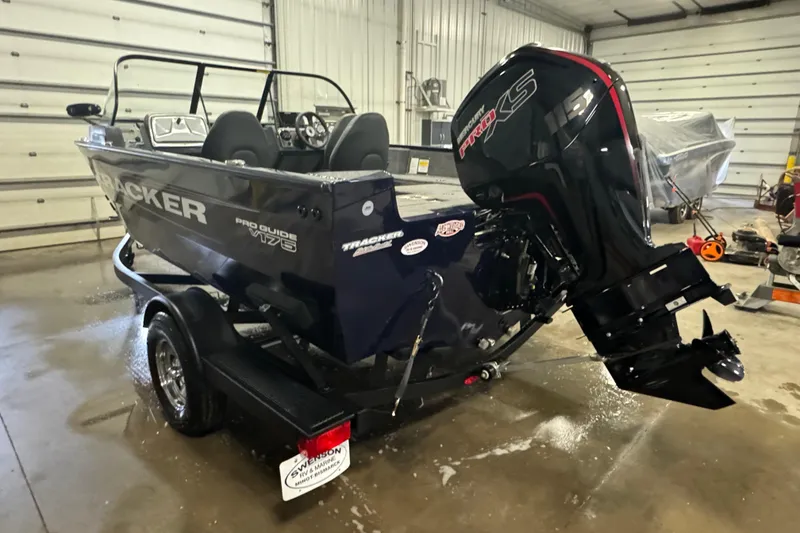 Slide: The Image of 2025 Tracker Pro Guide V-175 Combo boat with powerful outboard motor in a garage setting. - 4
