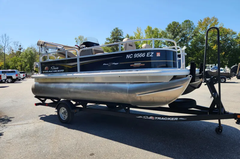 Slide: The Image of 2023 Sun Tracker Bass Buggy 16 XL Select pontoon boat on trailer in parking lot. - 5