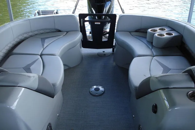 Slide: The Image of 2024 Manitou LX 25 RFX boat interior with gray seating and cup holders. - 3
