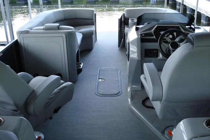 Slide: The Image of 2024 Manitou LX 25 RFX boat interior with modern seating and steering console. - 4