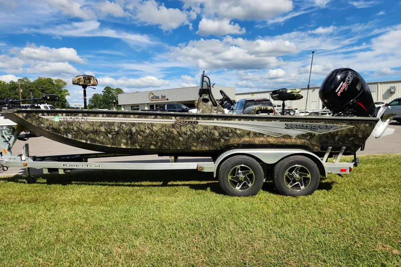 Slide: The Image of 2024 Ranger RB200 boat with camouflage design on a trailer, parked on grass under a blue sky. - 6