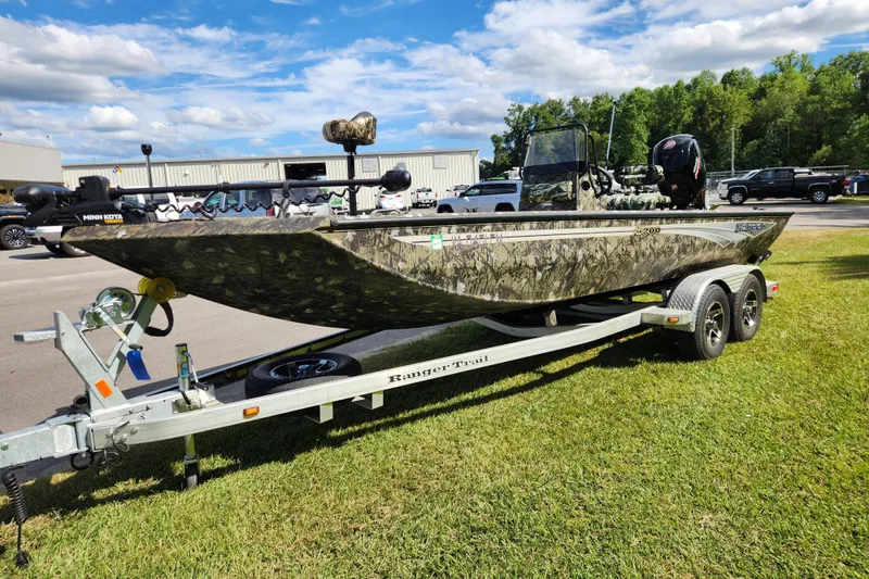 Slide: The Image of 2024 Ranger RB200 boat on trailer, camo design, parked on grass under blue sky. - 7