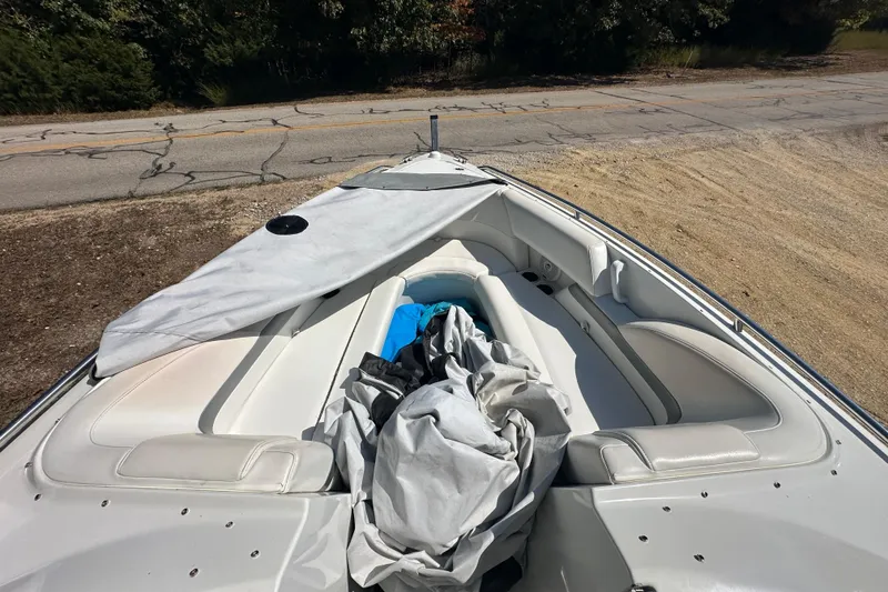 Slide: The Image of 2005 Formula 260 Bowrider boat with covered seating area, parked on a roadside. - 15