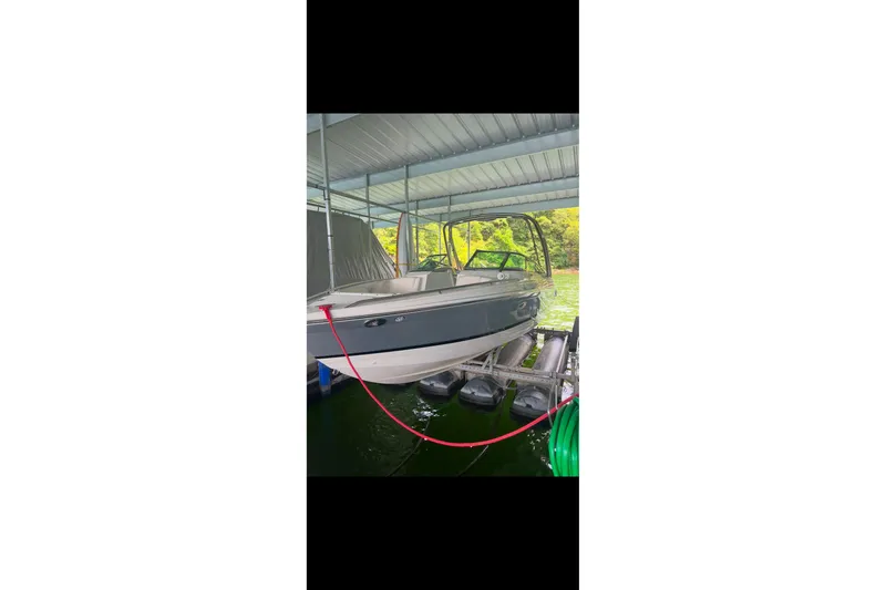 Slide: The Image of 2005 Formula 260 Bowrider boat on trailer, parked outdoors under clear blue sky. - 2