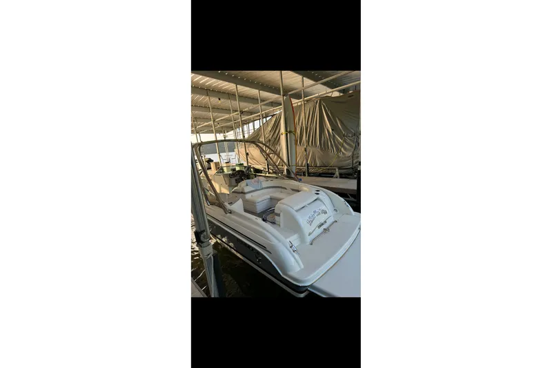 Slide: The Image of 2005 Formula 260 Bowrider boat on trailer, parked outdoors under clear blue sky. - 4