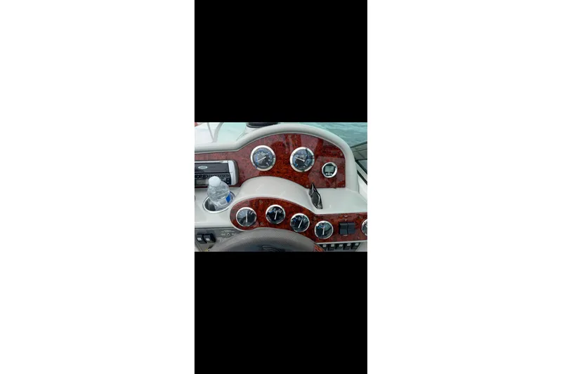 Slide: The Image of 2005 Formula 260 Bowrider interior with white seating and steering wheel, parked outdoors. - 7