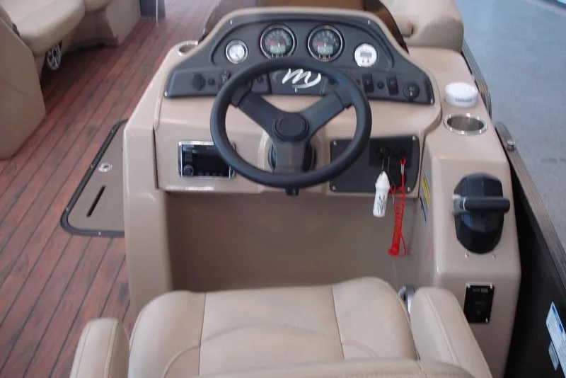 Slide: The Image of 2016 Manitou 23 VP Aurora boat dashboard with steering wheel and gauges. - 3