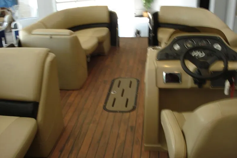 Slide: The Image of Interior of 2016 Manitou 23 VP Aurora pontoon boat with beige seating and wooden flooring. - 5