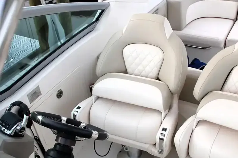 Slide: The Image of 2017 Chaparral 310 Signature boat interior with luxurious white seating and steering wheel. - 19