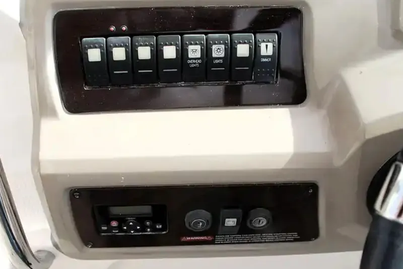 Slide: The Image of Control panel of a 2017 Chaparral 310 Signature boat with switches and dials. - 23