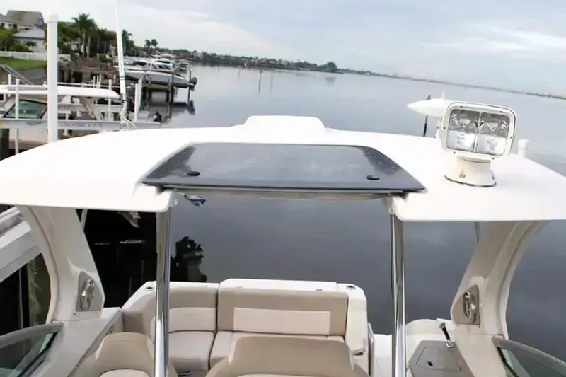 Slide: The Image of 2017 Chaparral 310 Signature boat docked by calm waters, featuring a sleek design and spacious seating. - 30