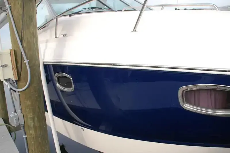 Slide: The Image of 2017 Chaparral 310 Signature boat docked, featuring sleek blue and white exterior. - 6