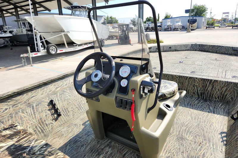Slide: The Image of 2025 Tracker Grizzly 2072 CC boat interior with camouflage design and steering console. - 11