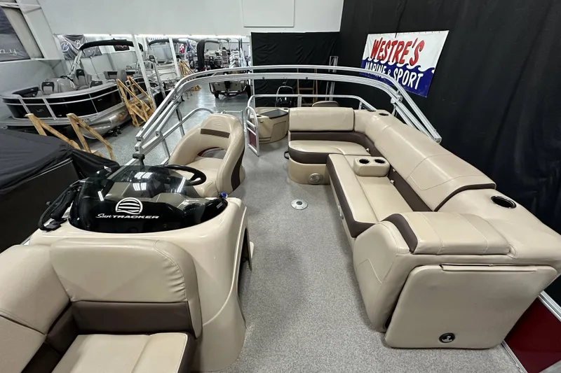 Slide: The Image of 2018 Sun Tracker SFB20 pontoon boat with beige seating in showroom. - 12