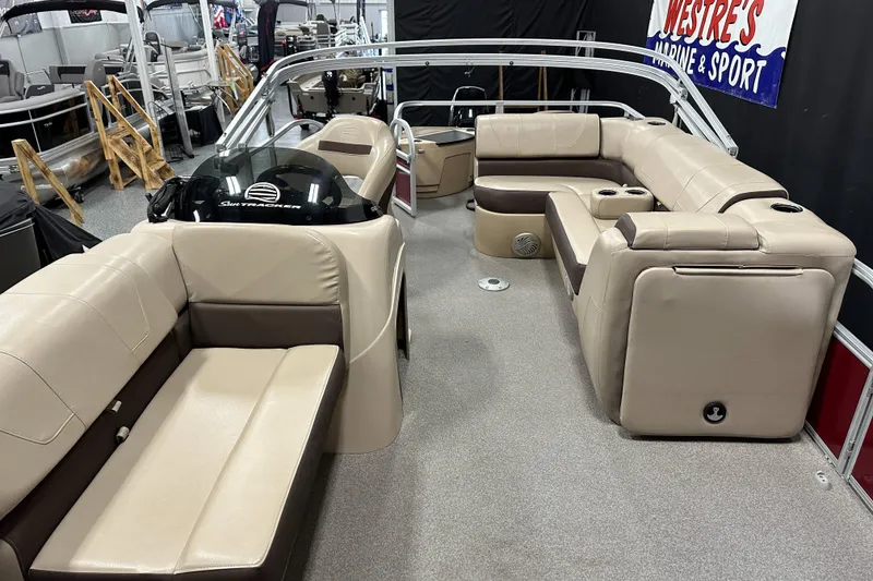 Slide: The Image of 2018 Sun Tracker SFB20 pontoon boat interior with beige seating and steering console. - 14
