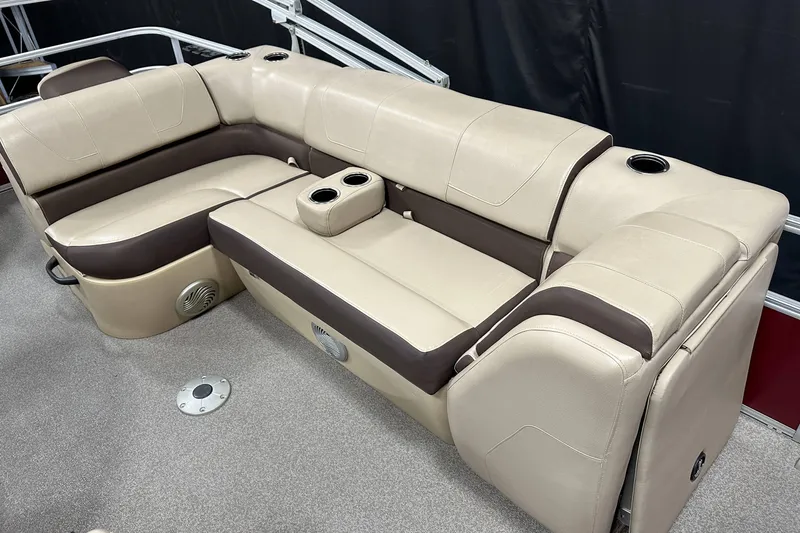 Slide: The Image of 2018 Sun Tracker SFB20 boat interior with beige and brown seating, cup holders, and speakers. - 15
