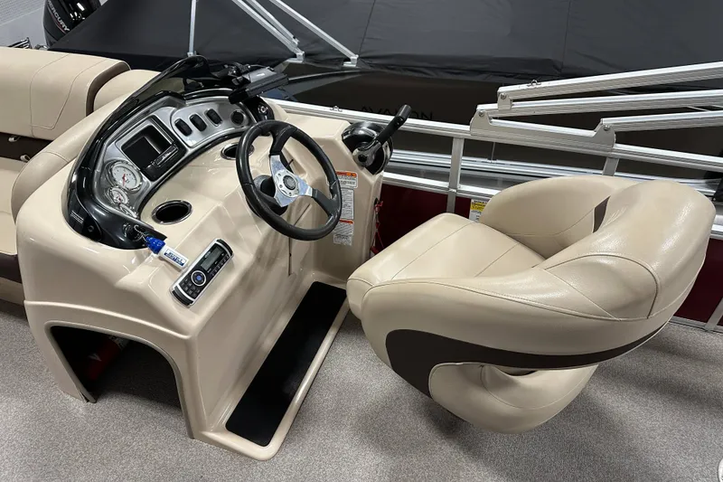 Slide: The Image of 2018 Sun Tracker SFB20 boat console with steering wheel and beige captain's chair. - 16
