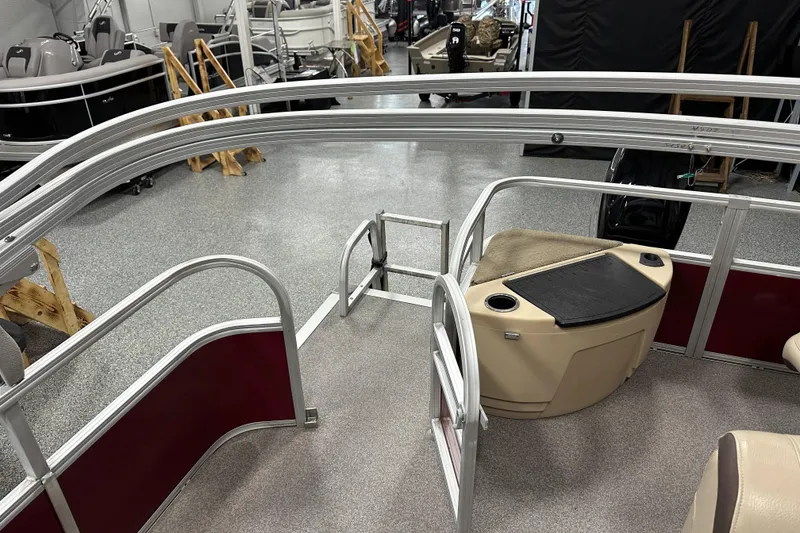 Slide: The Image of 2018 Sun Tracker SFB20 pontoon boat interior with seating and storage, displayed in showroom. - 17