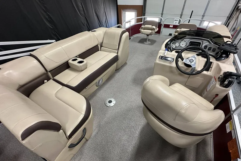 Slide: The Image of 2018 Sun Tracker SFB20 pontoon boat interior with beige seating and steering console. - 21