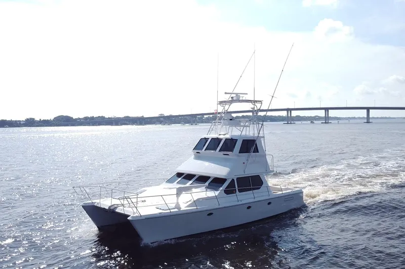 Slide: The Image of Luxurious 2000 Voyager 44 yacht cruising on a sunny day near a bridge. - 1