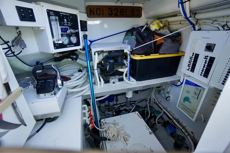 Slide: The Image of Engine room of a 2000 Venturer 44 boat, featuring control panels and storage. - 102