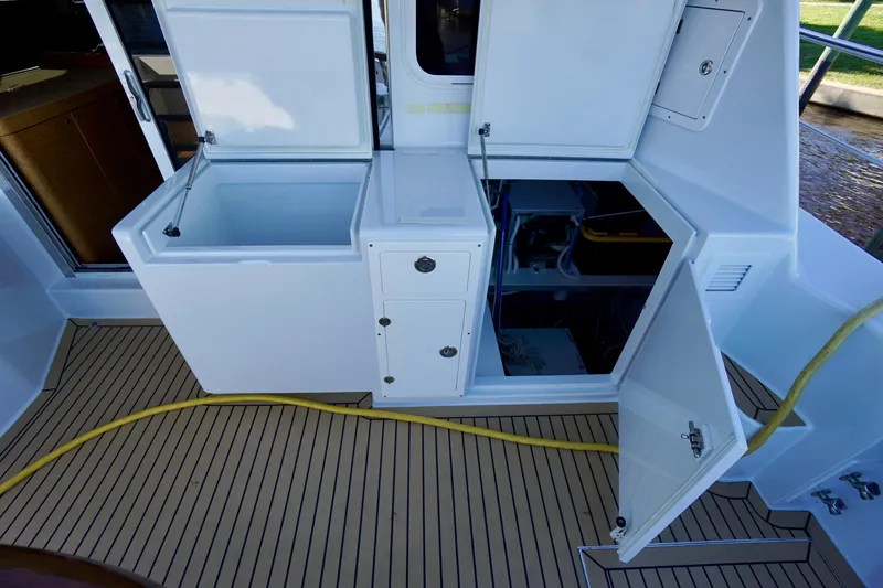 Slide: The Image of Open storage compartments on a 2000 Venturer 44 boat deck with yellow hose. - 103