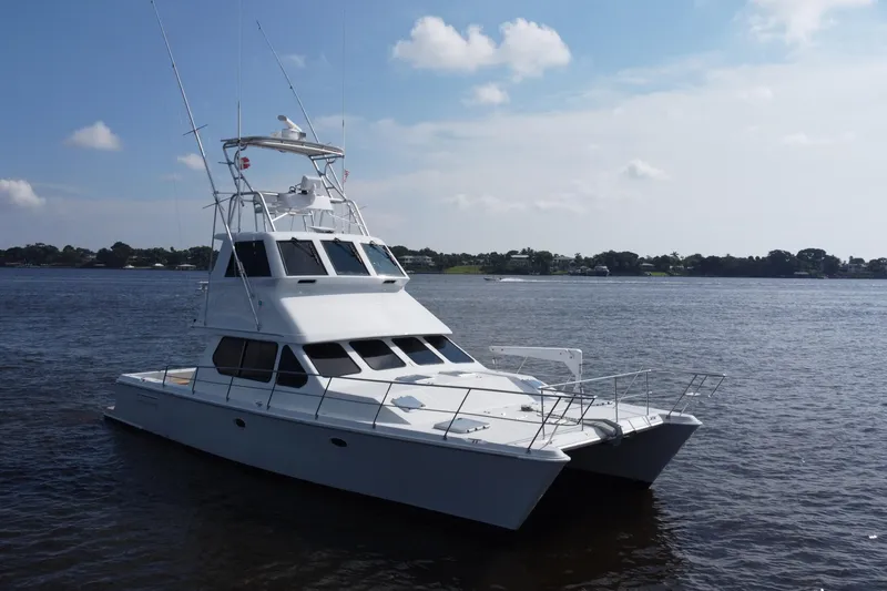Slide: The Image of 2000 Voyager 44 yacht on calm water under a clear sky. - 13