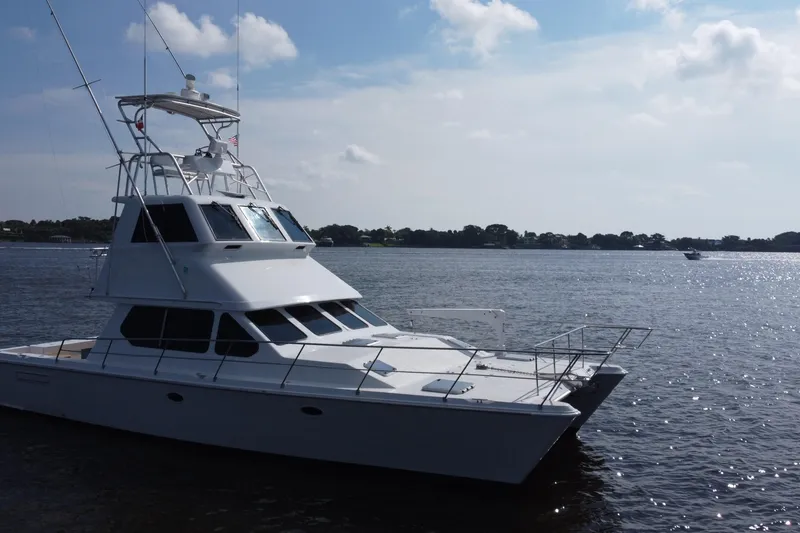 Slide: The Image of White Voyager 44 yacht from 2000 on calm water under a partly cloudy sky. - 15