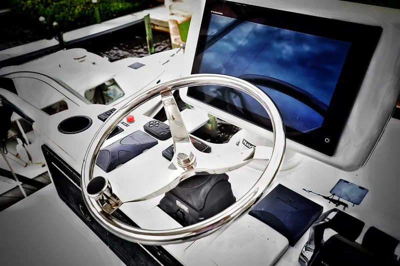 Slide: The Image of Steering wheel and navigation system of a 2000 Venturer 44 boat. - 48