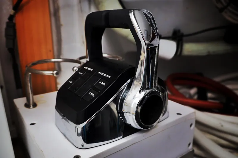 Slide: The Image of Boat throttle control lever on a 2000 Venturer 44 yacht, featuring chrome and black design. - 49