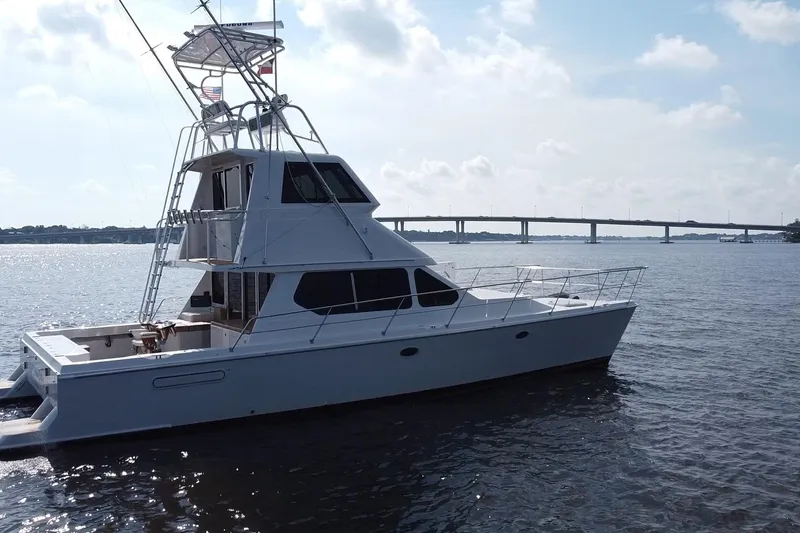 Slide: The Image of Voyager 44 yacht from 2000 on a calm river with a bridge in the background. - 6