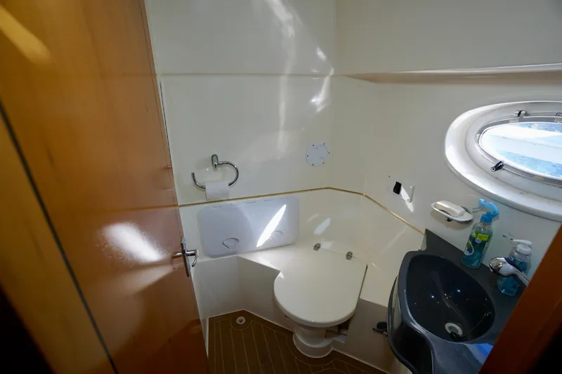 Slide: The Image of Bathroom interior of 2000 Venturer 44 yacht with toilet, sink, and porthole window. - 74