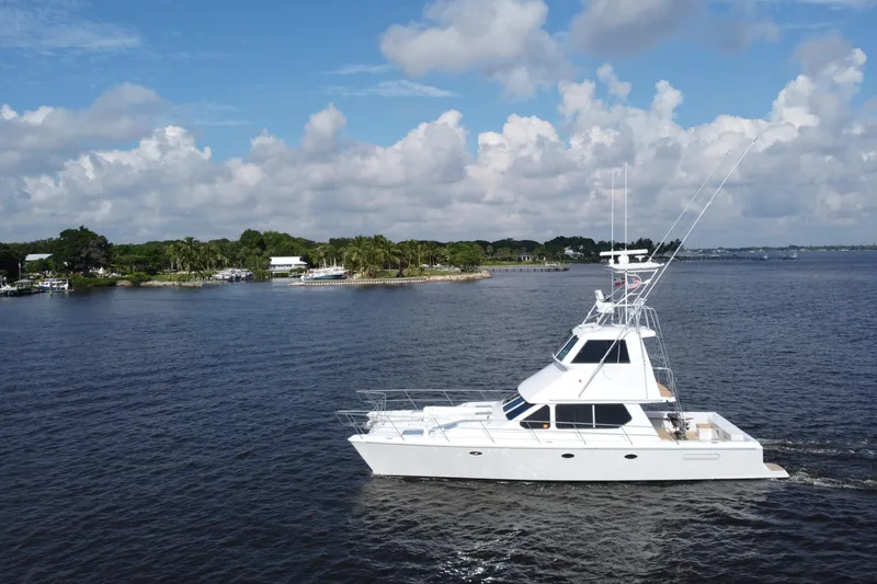 Slide: The Image of White Voyager 44 yacht cruising on a calm lake with a scenic shoreline. - 8
