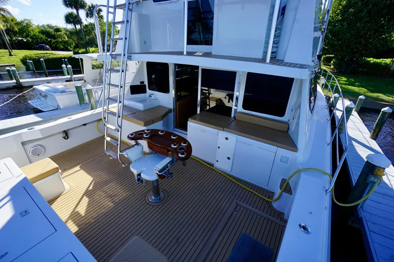 Slide: The Image of 2000 Venturer 44 yacht deck with seating, fishing chair, and ladder in marina setting. - 82