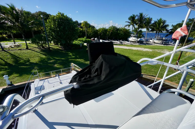 Slide: The Image of Venturer 44 yacht deck with scenic waterfront view, palm trees, and clear blue sky. - 84