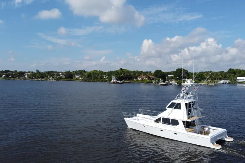 Slide: The Image of White Voyager 44 yacht cruising on a calm lake under a blue sky with clouds. - 9