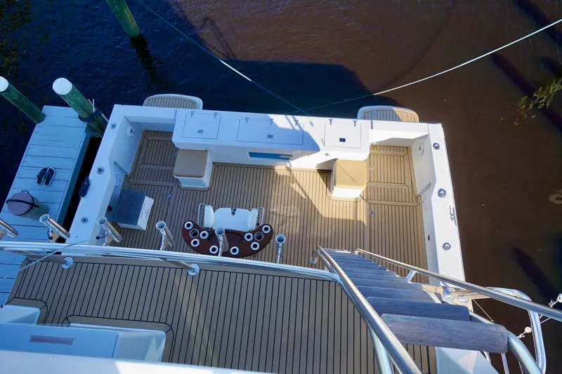 Slide: The Image of Deck view of 2000 Venturer 44 yacht with wooden flooring and seating area. - 90
