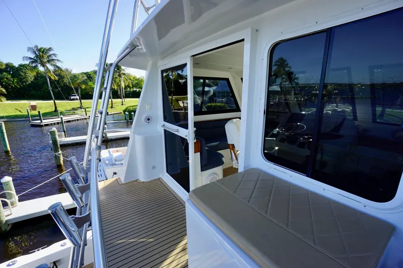 Slide: The Image of 2000 Venturer 44 yacht deck with seating, docked near palm trees and water. - 92
