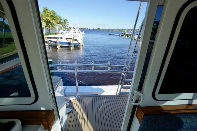 Slide: The Image of View from Venturer 44 yacht, 2000 model, overlooking a serene marina with palm trees. - 98