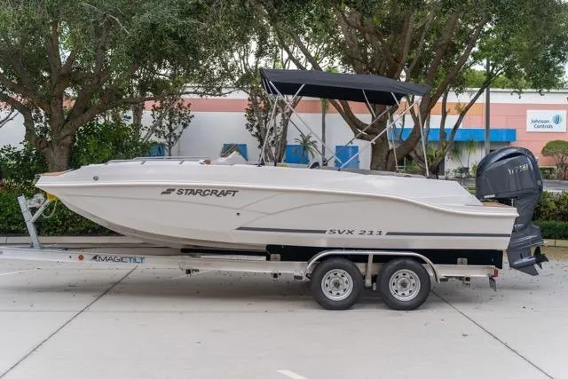 Slide: The Image of 2026 Starcraft SVX 211 OB boat on trailer, parked outdoors. - 0