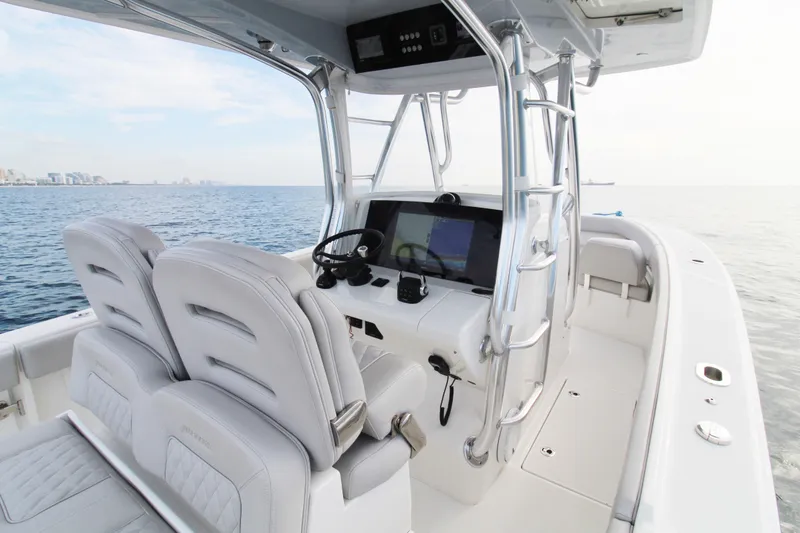 Slide: The Image of 2019 Jupiter 30 HFS boat interior with dual seats and navigation console on open water. - 1