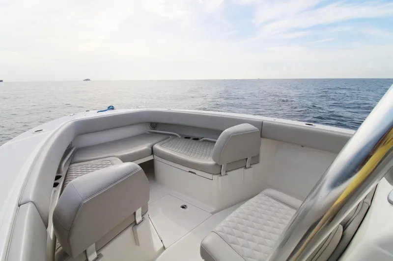 Slide: The Image of 2019 Jupiter 30 HFS boat interior with cushioned seating, overlooking calm ocean waters. - 12