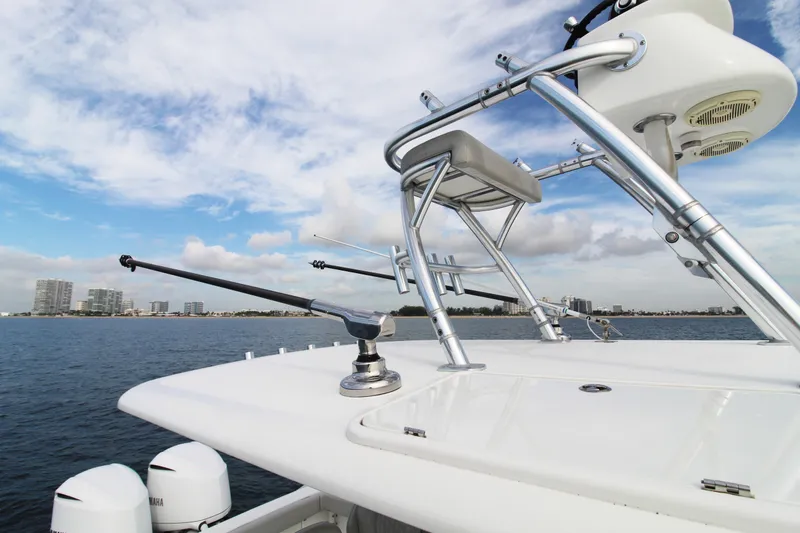 Slide: The Image of 2019 Jupiter 30 HFS boat with fishing equipment on a calm sea, city skyline in background. - 19